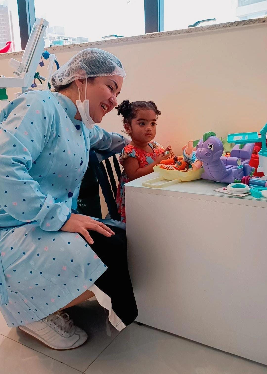Dentista da Anavoig brincando com criança pequena antes do atendimento