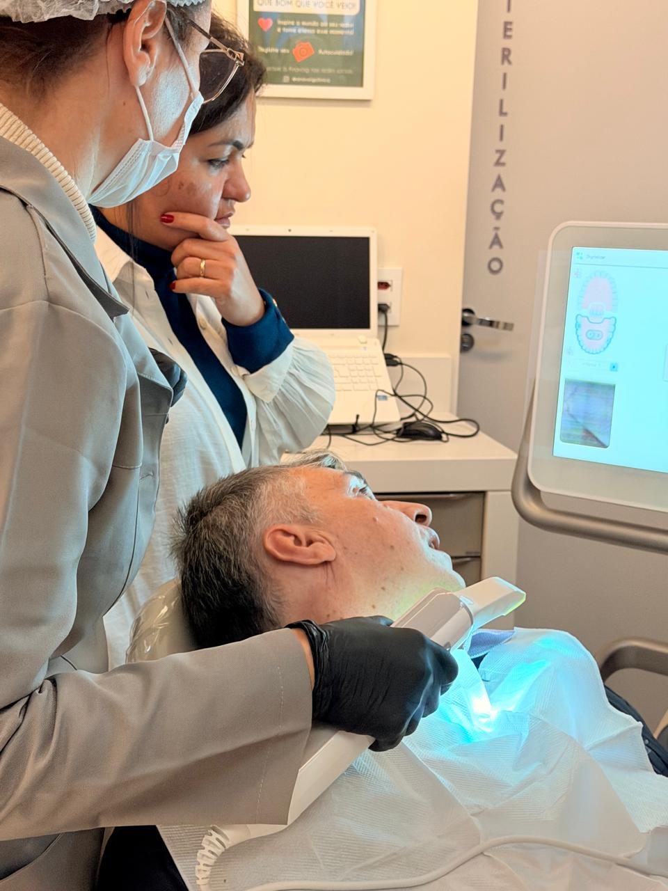Escaneamento intraoral digital sendo realizado na Clínica Anavoig com acompanhamento em tela